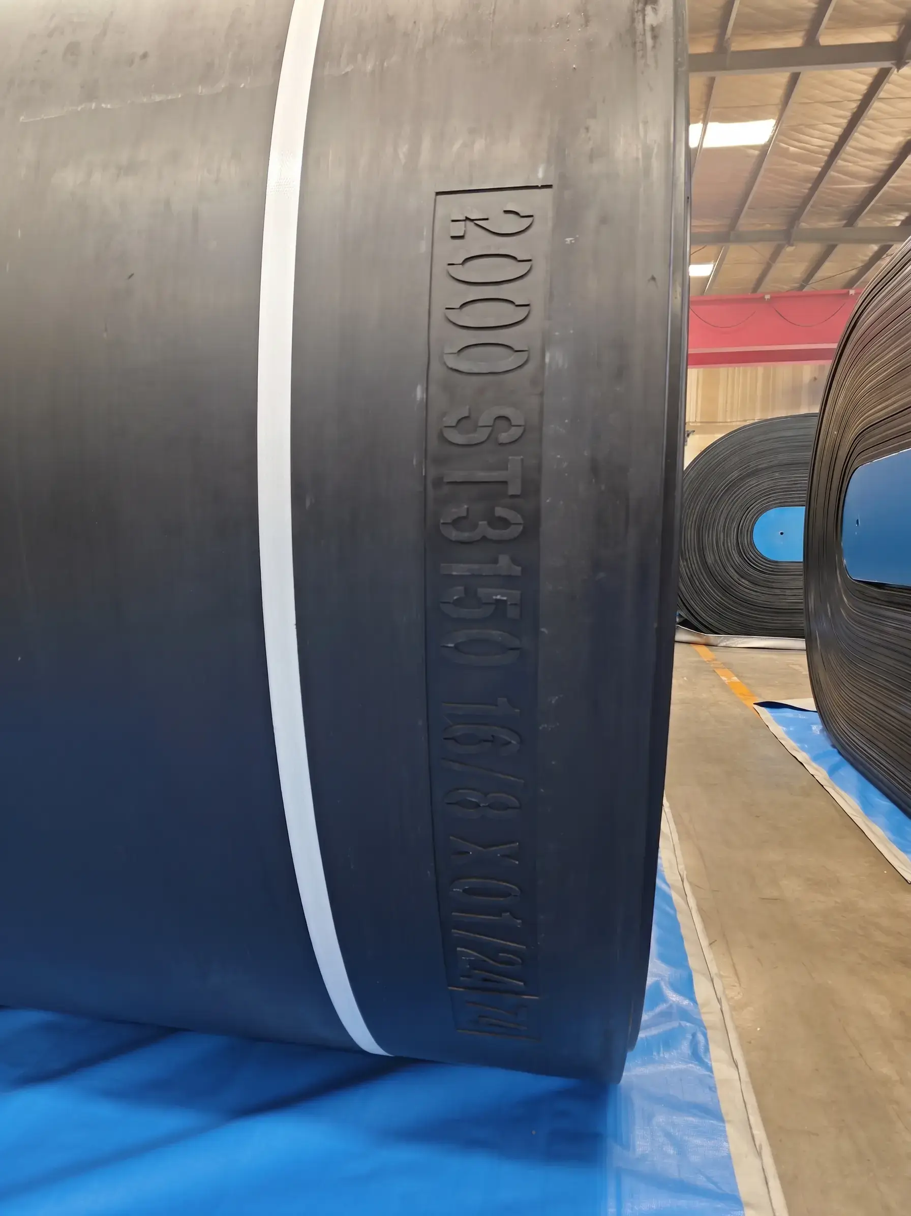 Close-up of steel cord rubber conveyor belt with embossed specification ST3150 and DIN standard marking